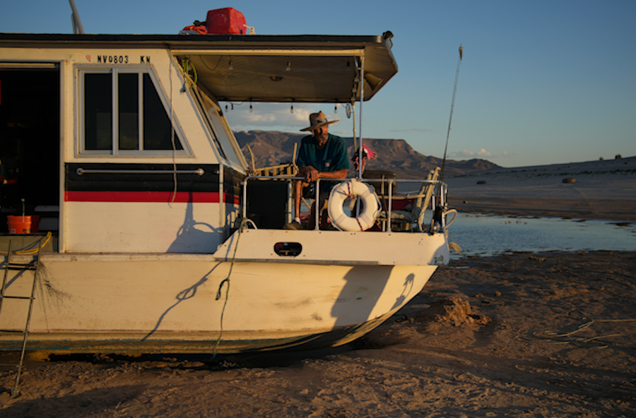 Craig Miller sits in his stranded houseboat at the Lake Mead National Recreation Area, Thursday, June 23, 2022, near Boulder City, Nev. Miller had been living on the stranded boat for over two weeks after engine trouble and falling lake levels left the boat above the water level.